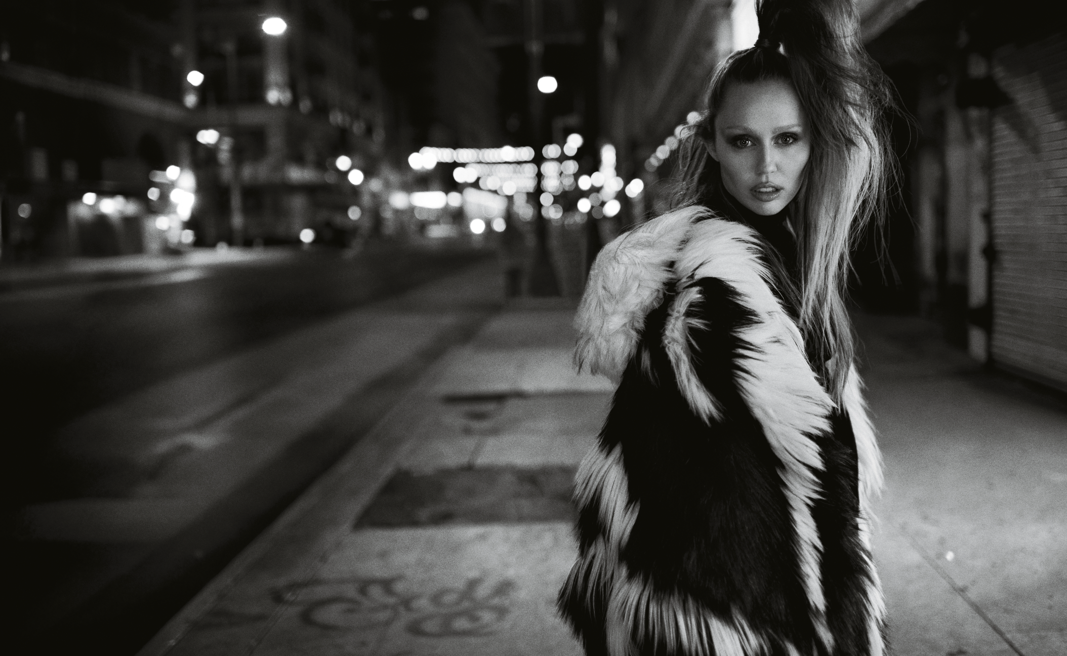 Modelo con abrigo peludo en calle nocturna